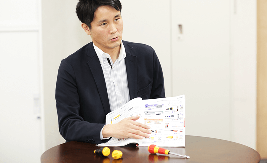 ドライバーを手に取りながら話す藤本さん