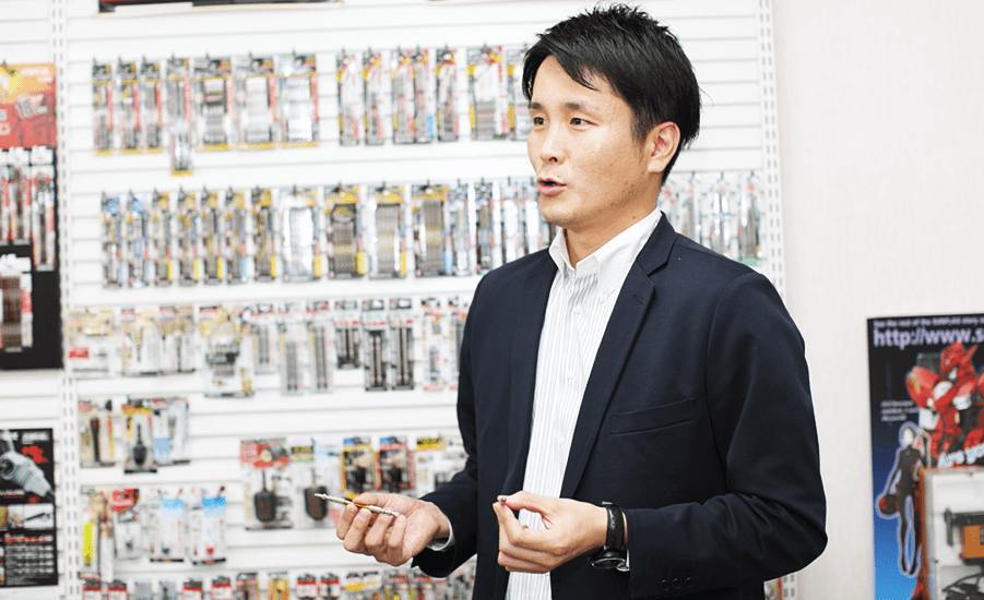 SUNFLAG製品たちの前で話す藤本さん